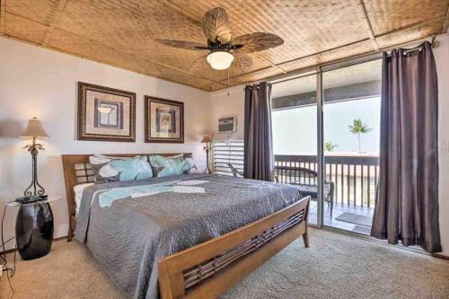 1 dormitorio con 1 cama, ventilador de techo y balcón en Reduced Price! Top Floor Kailua Bay View Walk to Kona Village AC King Bed, en Kailua-Kona