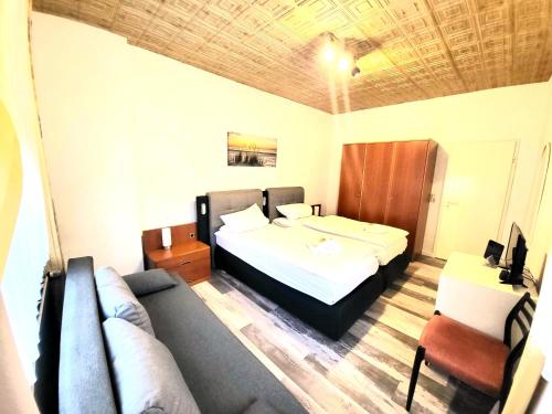 ein Hotelzimmer mit einem Bett und einem Sofa in der Unterkunft City Center Hotel Garni Cuxhaven in Cuxhaven