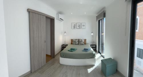 um quarto com uma cama num quarto branco em CASA LOPES em Olhão
