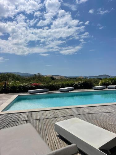 a swimming pool on top of a wooden deck at CHAMBRE D HOTE in Porticcio