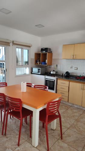 cocina con mesa de madera y sillas rojas en Casa con Garage Puerto Iguazú, zona residencial en Puerto Iguazú