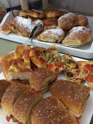 ein Teller mit Sandwiches und Gebäck auf einem Tisch in der Unterkunft B&B San Vito in San Vito lo Capo