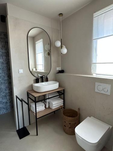 ein Bad mit einem Waschbecken und einem Spiegel in der Unterkunft nAmore in Pisak