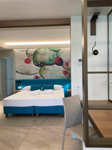 ein Schlafzimmer mit einem Bett und einem Wandgemälde in der Unterkunft Villaggio Marco Polo in Santa Domenica