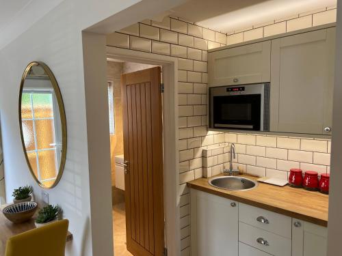 a kitchen with a sink and a mirror at No 64 Bed and Breakfast in Lymington