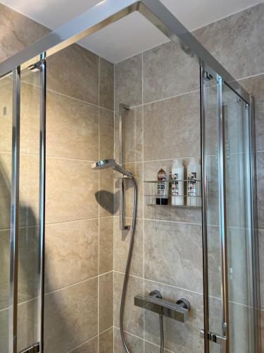 a shower stall with a glass door in a bathroom at No 64 Bed and Breakfast in Lymington