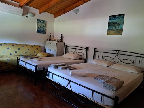 duas camas num quarto com um sofá em Garden House-Free transfer from airport em Artemida