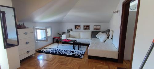 uma sala de estar com um sofá branco e uma mesa em Yana home em Donja Lastva