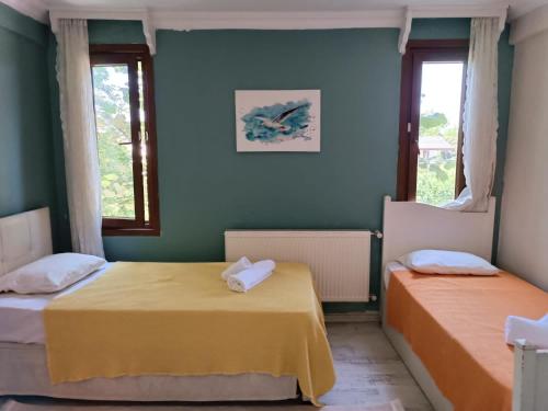 two beds in a room with two windows at Villa Telpher in Sapanca