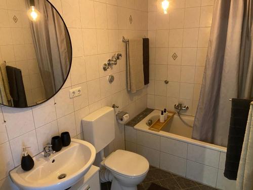 La salle de bains est pourvue d'un lavabo, de toilettes et d'une baignoire. dans l'établissement CHALET_3 Design Appartments, à Waldbüttelbrunn