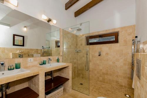 a bathroom with two sinks and a shower at Luxurious Refuge in National Park on Island - heated Pool - 5 minutes to Ocean in Mahón