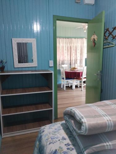 Pousada Atlântica stay home في ترامانداي: غرفة نوم بسرير وغرفة مع طاولة