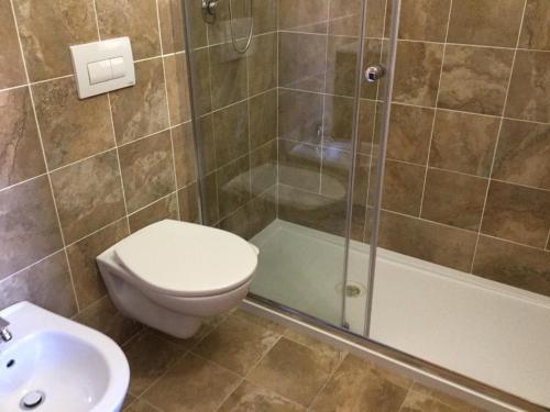 a bathroom with a toilet and a shower and a sink at S' Agrùstu in Orosei