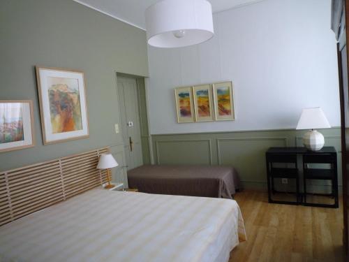 une chambre avec deux lits et une table avec des lampes dans l'établissement Appartement Avignon centre intra muros Cour extérieure Parking privé gratuit, à Avignon