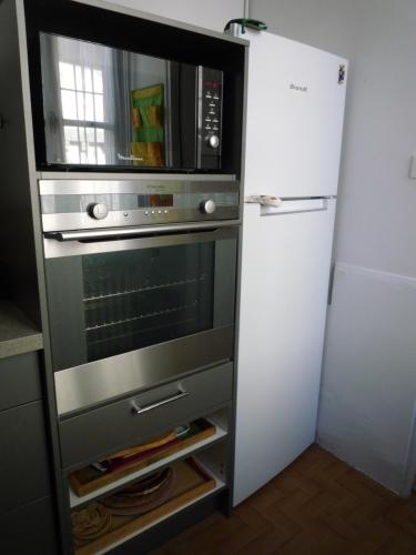 - un four micro-ondes dans une armoire à côté d'un réfrigérateur dans l'établissement Appartement Avignon centre intra muros Cour extérieure Parking privé gratuit, à Avignon