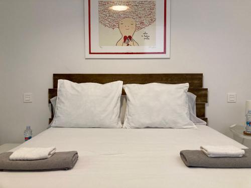 1 dormitorio con 1 cama con sábanas y almohadas blancas en Apartamento centro con parking privado en Zaragoza