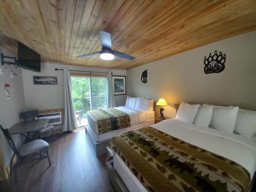 1 dormitorio con 2 camas, escritorio y ventana en Carter Lodge - On The River, en Chimney Rock