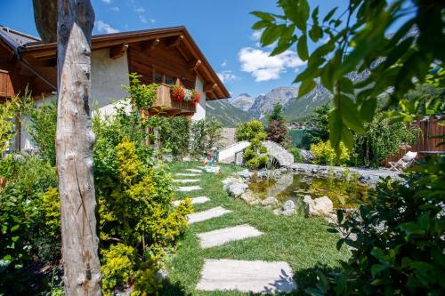 un giardino con un sentiero e una casa di Agriturismo San Gallo a Bormio