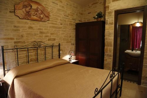 a bedroom with a bed in a stone wall at Il Quadrifoglio in Trapani