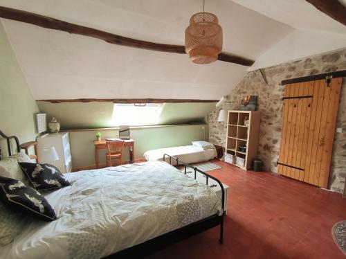 een slaapkamer met een groot bed en een tafel bij Chambres d'Hôtes Montjouan in Larochemillay