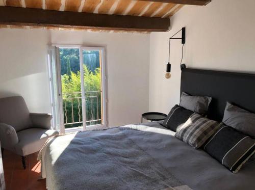 a bedroom with a bed and a chair and a window at Villa de charme, avec piscine, 6 personnes in Éguilles
