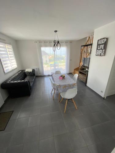 un salon avec une table et un canapé dans l'établissement Vue sur Mer, à Criel-sur-Mer