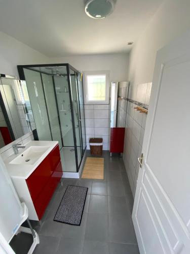 uma casa de banho com um lavatório vermelho e um chuveiro em Vue sur Mer em Criel-sur-Mer