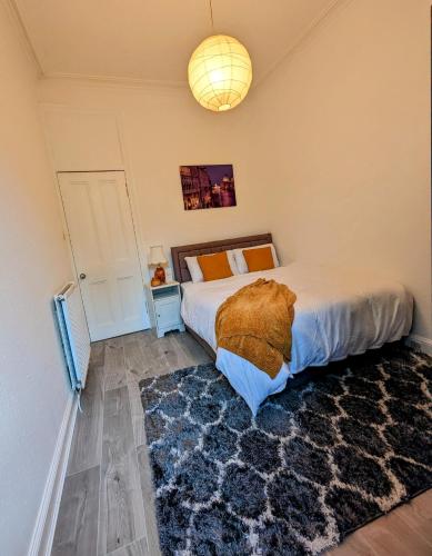 ein Schlafzimmer mit einem großen Bett und einem Teppich in der Unterkunft Cozy Room Close To The City in Edinburgh