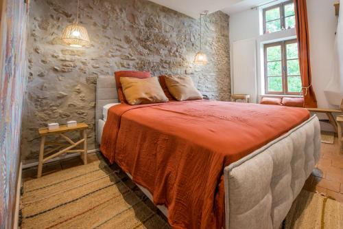 TraizeChâteau beyrin的一间带床和石墙的卧室