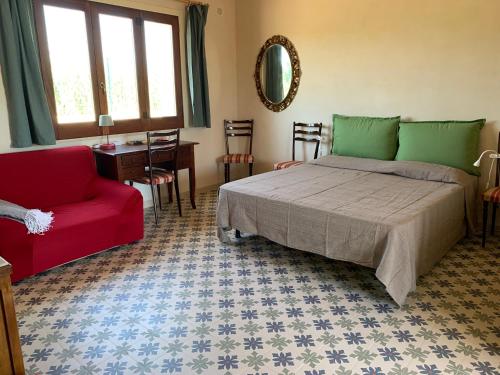 ein Schlafzimmer mit einem Bett und einem roten Stuhl in der Unterkunft Vivi-Vendicari in Noto