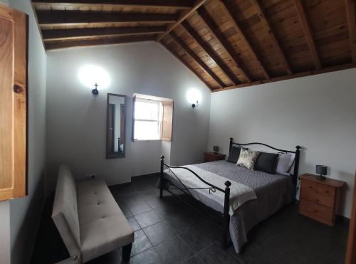 1 dormitorio con 1 cama, 1 silla y 1 ventana en Casa das Hortênsias, en Horta