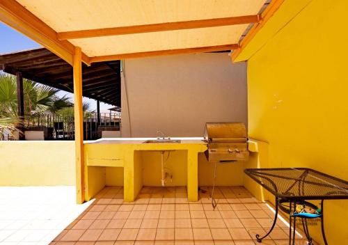 a yellow patio with a table and a grill at Condo 3 Easy Walk to San Felipe Malecon in San Felipe