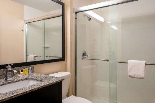 y baño con ducha, aseo y lavamanos. en Super 8 by Wyndham Columbus West, en Columbus