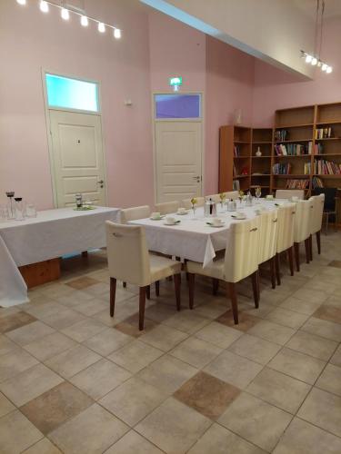una grande stanza con un lungo tavolo e sedie di Kahvila ja Majoitus Tmi Tiina Soilu a Joutsa