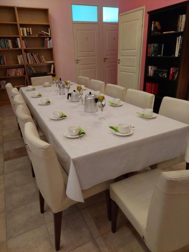 une grande table avec des chaises et un tissu de table blanc dans l'établissement Kahvila ja Majoitus Tmi Tiina Soilu, à Joutsa