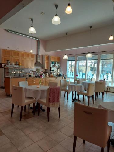 a dining room with tables and chairs and a kitchen at Kahvila ja Majoitus Tmi Tiina Soilu in Joutsa