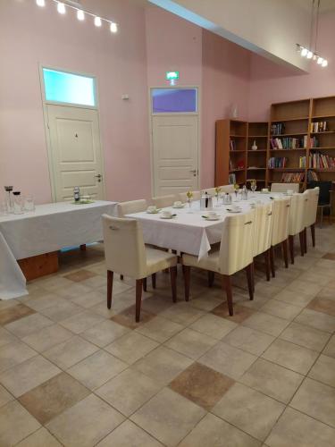 uma grande sala de jantar com mesa e cadeiras em Kahvila ja Majoitus Tmi Tiina Soilu em Joutsa