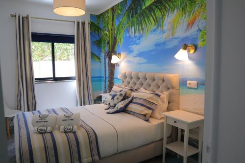 um quarto com uma cama com um mural de palmeira em PH in Aroeira Lisbon - Beach & Golf em Aroeira