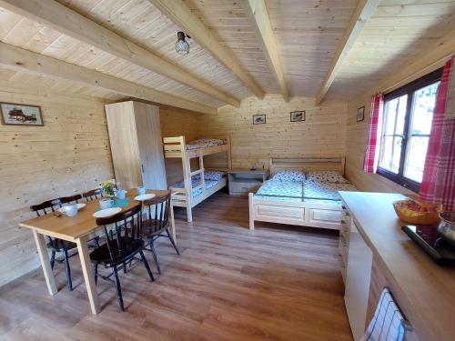 una habitación con una mesa y una cama en una cabaña en Autokemp / Speleocamp Malužiná, en Malužiná