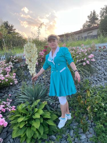 萊沃恰的住宿－Villa Mia，站在花园中的身着蓝色衣服的女人