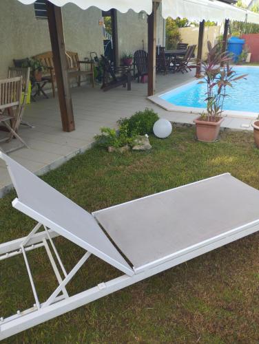 eine weiße Tischtennisplatte neben einem Swimmingpool in der Unterkunft Zen paradise in Sainte-Anne