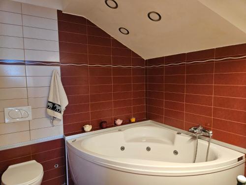 a bathroom with a bath tub and a toilet at Magic Eden Rijeka in Rijeka