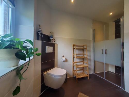 a bathroom with a toilet and a shower at NordseeLiebe - Zeit Für Meer in Bredstedt