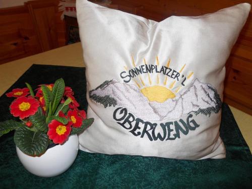 a pillow with a baseball jersey on it next to flowers at Familienbauernhof Imitz, Ferienwohnung in Spital am Pyhrn