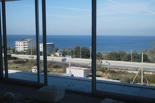 a window with a view of a road and the ocean at فيلا باطلالة بانورامية على البحر وقريبة من المركز in Yalova