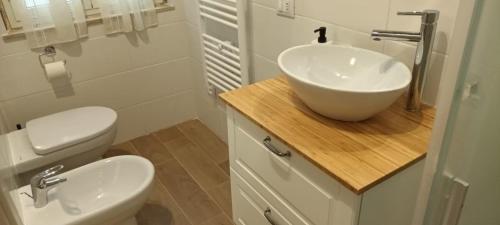 ein Badezimmer mit einem weißen Waschbecken und einem WC in der Unterkunft Il porto di Ale e Kat in Livorno