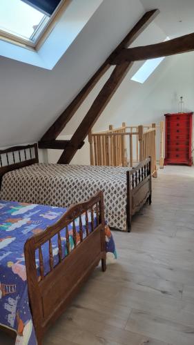 a bedroom with two beds in a attic at Maison proche Zoo de Beauval in Poulaines