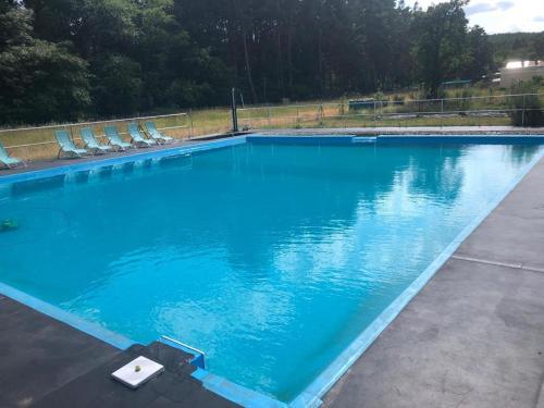 una gran piscina azul con sillas. en Naturheilcamp Götzer Berge, en Groß Kreutz