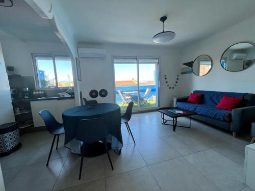 un salon avec une table et un canapé dans l'établissement Roussillon appart avec terrasse, à Perpignan