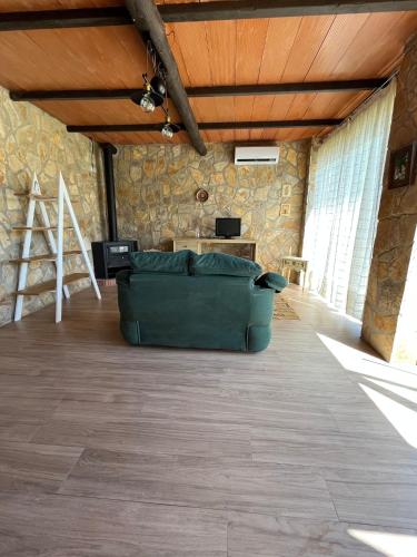 a large living room with a green couch in the middle at La Estacada in Lora del Río